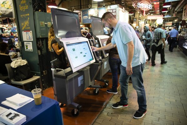 FILE - In this June 13, 2019, file photo, Steve Marcinkus, an Investigator with the Office of the City Commissioners, demonstrates the ExpressVote XL voting machine at the Reading Terminal Market i...