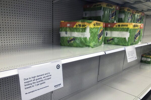 The quantity of paper towels customers can buy is listed at a Target Store, Tuesday, Nov. 17, 2020, in Bloomington, Minn. A surge of new coronavirus cases in the U.S. is sending people back to stores to stockpile again, leaving shelves bare and forcing retailers to put limits on purchases. (AP Photo/Jim Mone)