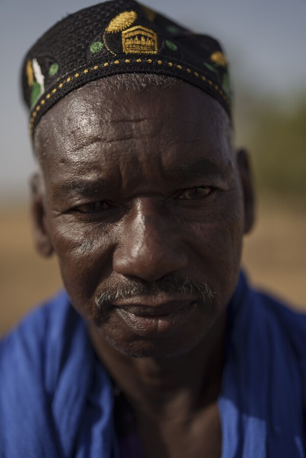 Mamadou Samba Sow, 63, stands for a portrait in the village of Anndiare, in the Matam region of Senegal, Thursday, April 13, 2023. A father of fourteen children, the herder who came from Mauritania to Senegal eighteen years ago says that before raising cows was more profitable and more respected but now the herders are moving more towards raising more sheep. Sow believes that transhumance is important and largely covers the country's needs, especially for the Eid al-Adha festival, known locally as Tabaski. "Our whole life goes around our livestock", he says. (AP Photo/Leo Correa)
