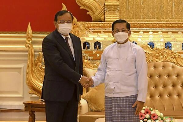 In this photo provided by the Military True News Information Team, Myanmar State Administration Council Chairman Senior General Min Aung Hlaing, right, shakes hands with Cambodian Foreign Minister and ASEAN Special Envoy to Myanmar Prak Sokhonn during a meeting in Naypyitaw, Myanmar, Monday, March 21, 2022. Sokhonn arrived Monday in Myanmar's capital Naypyitaw on his mission as a special regional envoy seeking to facilitate peacemaking in the strife-torn, military-led nation. (Military True News Information Team via AP)