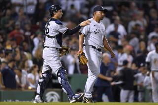 New York Yankees' Kyle Higashioka, left, celebrates with Wandy Peralta after the Yankees defeated the Boston Red Sox 7-6 in 10 innings in a baseball game Tuesday, Sept. 13, 2022, in Boston. (AP Photo/Steven Senne)