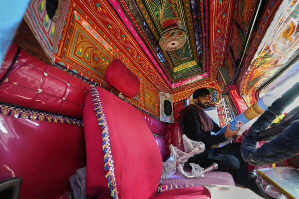 Driver Farrukh Sana checks items inside the cabin of a newly refurbished truck painted with traditional artwork at a yard for workshops in Rawalpindi, Pakistan, Monday, April 21, 2025. (AP Photo/Anjum Naveed)