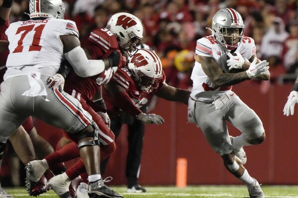 Ohio State's TreVeyon Henderson (32) runs during the first half of an NCAA college football game against Wisconsin Saturday, Oct. 28, 2023, in Madison, Wis. (AP Photo/Morry Gash)