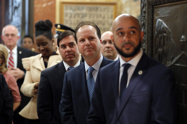 FILE - State lawmakers, right to left, Rep. Royce Duplessis, D-New Orleans, Rep. Paul Hollis, R-Covington, Rep. Nick Muscarello, R-Hammond, and Rep. Katrina Jackson, D-Monroe, line up to escort Louisiana Gov. John Bel Edwards at the opening of the annual state legislative session in Baton Rouge, La., April 8, 2019. (AP Photo/Gerald Herbert, Pool, File)