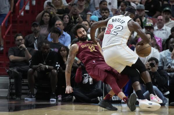 Cleveland Cavaliers guard Ricky Rubio (13) goes down as Miami Heat forward Jimmy Butler (22) drives to the basket during the first half of an NBA basketball game, Wednesday, March 8, 2023, in Miami. (AP Photo/Wilfredo Lee)