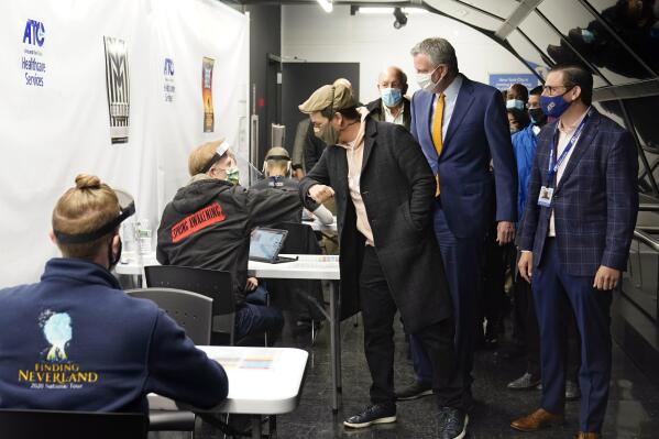 FILE -- In this April 12, 2021 file photo, actor Lin-Manuel Miranda, center, bumps elbows with a worker at the ATC Vaccination Services site in New York's Times Square. He's accompanied by New York Mayor Bill de Blasio, second from right, and ATC Alert founder & CEO Jordan Savitsky, right. Nearly 900 people received expired Pfizer COVID-19 vaccine doses at the vaccination site in Times Square this month, health officials said Tuesday, June 15, 2021. (AP Photo/Richard Drew, Pool, File)