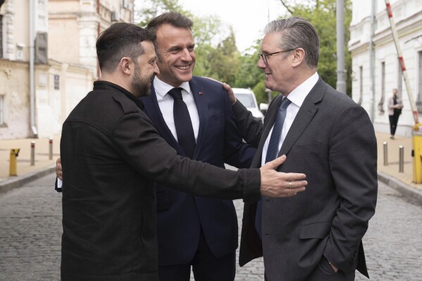 Ukrainian President Volodymyr Zelensky, left, Britain's Prime Minister Keir Starmer, right, and French President Emmanuel Macron, center, talk during a meeting in Kyiv, Ukraine, Saturday, May 10, 2025. (Stefan Rousseau/PA via AP, Pool)