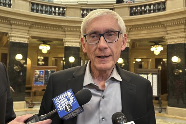 Wisconsin Gov. Tony Evers tells reporters in the state Capitol that Republican rejection of his appointees is "insanity" on Tuesday, Oct. 17, 2023, in Madison, Wisc. The state Senate was voting to reject four appointees made by Evers to the Wisconsin Department of Natural Resources Board. (AP Photo/Scott Bauer)
