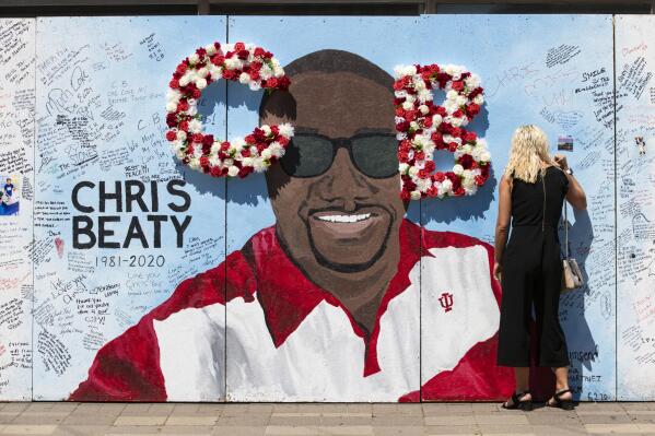 FILE - In this June 12, 2020 file photo, a mourner signs a tribute wall during a memorial service for former Indiana University football player Chris Beaty in Indianapolis. Three people have been convicted in the fatal shooting of a former Indiana University football player who was gunned down during unrest in Indianapolis following the death of George Floyd. (AP Photo/Michael Conroy File)