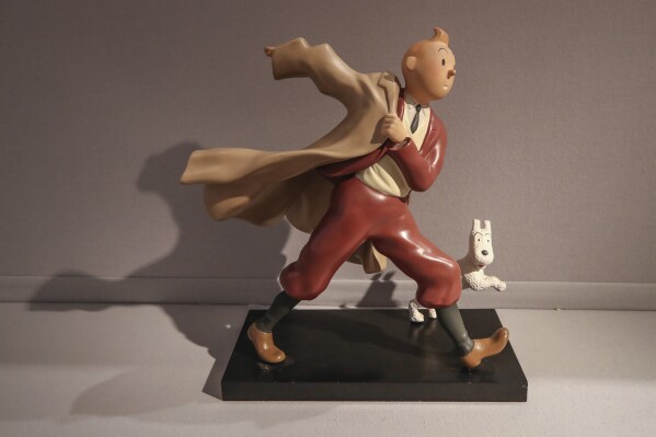 FILE - A 1988 polychrome resin sculpture of the comic character Tintin and his dog snowy from the 1941 "The Crab with the Golden Claws" album drawn by Belgian creator Herge is displayed at the Artcurial auction house in Paris, on Jan. 13, 2021. The Belgium international players taking part in the Euro soccer tournament this summer could well resemble a world-famous reporter. According to leaks on various specialized websites, the Belgium Euro 2024 away kit is a tribute to Tintin. The Belgian federation is set to unveil the new kit on Thursday March 14, 2024 during a press conference at the Hergé Museum. (AP Photo/Michel Euler, File)