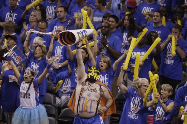 FILE - Oklahoma City Thunder fans cheer the team on against the Miami Heat during the second half at Game 1 of the NBA finals basketball series, Tuesday, June 12, 2012, in Oklahoma City. Oklahoma City voters on Tuesday, Dec. 12, 2023, approved a 1% sales tax for six years to help fund a new downtown arena for the NBA’s Thunder that is expected to cost at least $900 million. (AP Photo/Sue Ogrocki, File)