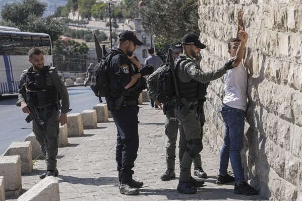 FILE - Israeli security forces conduct a security check on a Palestinian outside Jerusalem's Old City on Oct. 13, 2023. ore than 270 Palestinian citizens have been arrested in a crackdown on free speech and political activity since the Hamas attack, according to Adalah, an advocacy organization for Palestinians inside Israel. Palestinian citizens have also reported intimidation, firings and expulsions from universities, as well as surveillance of their online speech. (AP Photo/Mahmoud Illean, File)