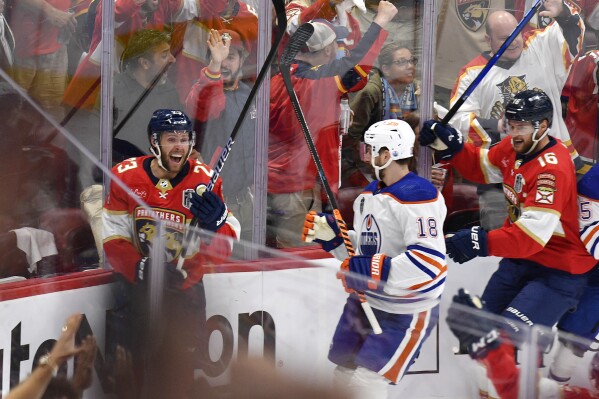 Florida Panthers center Carter Verhaeghe (23) celebrates with center Aleksander Barkov (16) after scoring a goal against the Edmonton Oilers during the first period of Game 1 of the NHL hockey Stanley Cup Finals Saturday, June 8, 2024, in Sunrise, Fla. (AP Photo/Michael Laughlin)