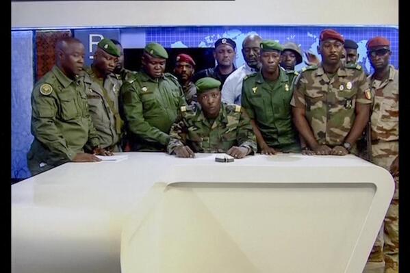 In this image made from video, an unnamed military officer identifying himself as the spokesperson of the National Committee for Rally and Development (CNRD), surrounded by others, makes an address to the nation from state television headquarters in the capital Conakry, Guinea Sunday, Sept. 5, 2021. Mutinous soldiers in the West African nation detained President Alpha Conde on Sunday after hours of heavy gunfire rang out near the presidential palace in the capital, then announced on state television that the government had been dissolved in an apparent coup d'etat. (Radio Television Guineenne via AP)
