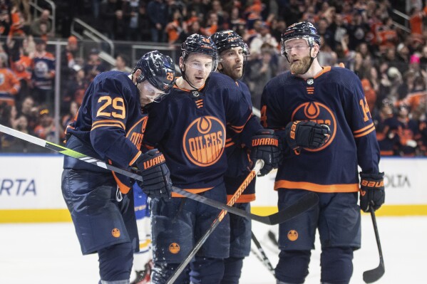 Edmonton Oilers' Leon Draisaitl (29), Zach Hyman (18), Evan Bouchard (2) and Mattias Ekholm (14) celebrate after a goal against the Buffalo Sabres during second-period NHL hockey game action in Edmonton, Alberta, Thursday March 21, 2024. (Jason Franson/The Canadian Press via AP)