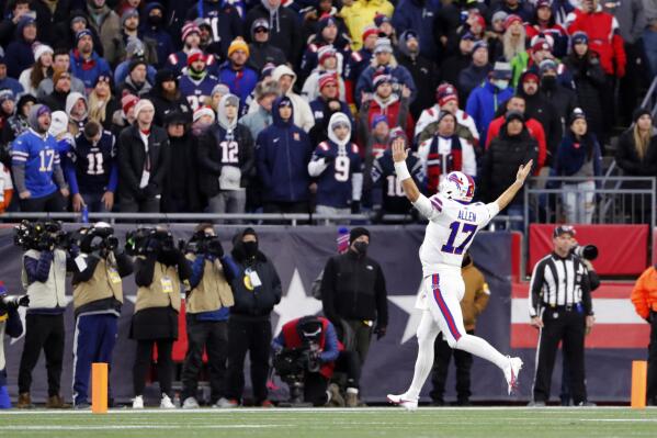 Buffalo Bills quarterback Josh Allen (17) celebrates to a stadium of New England Patriots fans after a touchdown by tight end Dawson Knox during the second half of an NFL football game, Sunday, Dec. 26, 2021, in Foxborough, Mass. (AP Photo/Winslow Townson)
