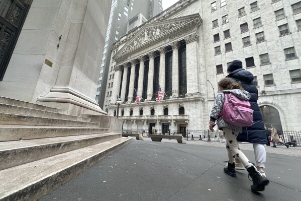 People pass the New York Stock Exchange on Wednesday, March 6, 2024, in New York. World shares are mostly higher after tumbling Big Tech stocks dragged Wall Street to its worst day in three weeks. (AP Photo/Peter Morgan)