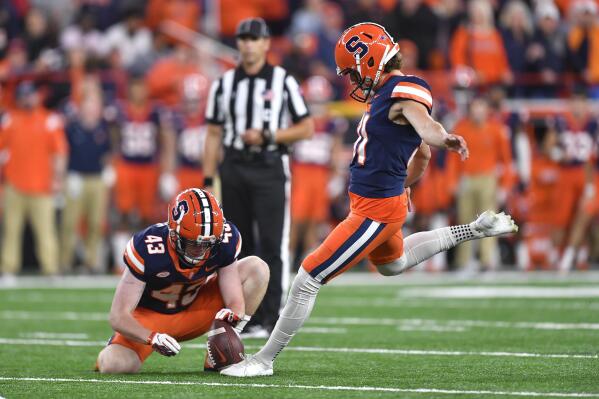 Syracuse's Andre Szmyt, right, kicks the go-ahead field goal from the hold of defensive back Cornell Perry (43) during the second half of the team's NCAA college football game against Virginia on Friday, Sept. 23, 2022, in Syracuse, N.Y. Syracuse won 22-20. (AP Photo/Adrian Kraus)
