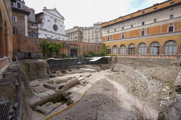 People walk in the excavation site of the ancient Roman emperor Nero's theater, 1st century AD, backdropped by the church of Santo Spirito in Sassia, during a press preview, in Rome, Wednesday, July 26, 2023. The ruins of Nero's Theater, an imperial theater referred to ancient Roman texts but never found, have been discovered under the garden of the future Four Season's Hotel, steps from the Vatican, after excavating the walled garden of the Palazzo della Rovere since 2020, as part of planned renovations on the Renaissance building. (AP Photo/Andrew Medichini)