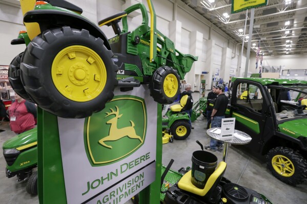 FILE - In this Feb. 23, 2018 file photo, John Deere products, including a toy tractor on the sign, are on display at the "Spring into Spring" home and garden trade show in Council Bluffs, Iowa, Deere & Co. posted strong quarterly results, but shares slid early after the agricultural machinery company cut its forecast for 2024 in what is expected to be a tight year for farmers. (AP Photo/Nati Harnik, FIle)