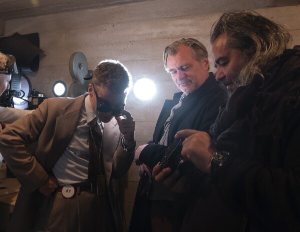 This image released by Universal Pictures shows actor Cillian Murphy, left, with writer-director-producer Christopher Nolan, center, and cinematographer Hoyte Van Hoytema on the set of "Oppenheimer." (Melinda Sue Gordon/Universal Pictures via AP)
