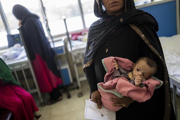 FILE - In this Wednesday, Sept. 15, 2021 file photo, an Afghan woman holds her 5-month-old daughter, Samina, at the malnutrition ward of the Indira Gandhi Children Hospital, in Kabul, Afghanistan. A month after the fall of Kabul, the question of how the world will get aid to citizens without enriching Afghanistan's Taliban rulers is haunting the country. The stakes have soared for Afghans, who along with the threat of famine and a collapsing health care system face a looming crisis as winter approaches. (AP Photo/Bernat Armangue, File)