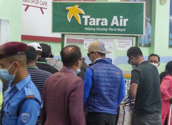 A signage of Tara Airlines is seen behind as a team of climbers prepare to leave for rescue operations from the Tribhuvan International Airport in Kathmandu, Nepal, Sunday, May 29, 2022. A small airplane with 22 people on board flying on a popular tourist route was missing in Nepal’s mountains on Sunday, an official said. The Tara Airlines plane, which was on a 15-minute scheduled flight to the mountain town of Jomsom, took off from the resort town of Pokhara, 200 kilometers (125 miles) east of Kathmandu. It lost contact with the airport tower shortly after takeoff. (AP Photo/Niranjan Shreshta)