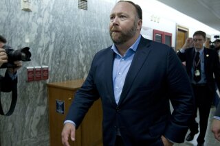 
              FILE - In this Wednesday, Sept. 5, 2018, file photo, Alex Jones, the right-wing conspiracy theorist, walks the corridors of Capitol Hill after listening to testimony on Capitol Hill in Washington. On Tuesday, Oct. 23, 2018, Twitter confirmed it has removed accounts linked to conspiracy-monger Alex Jones and Infowars. (AP Photo/Jose Luis Magana, File)
            