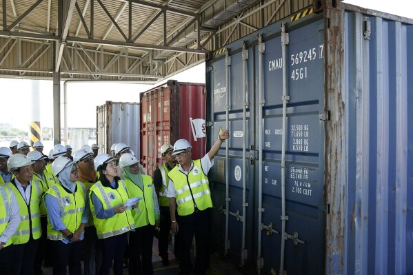 Malaysia's Environment Minister Yeo Bee Yin, third from left, inspects a container with plastic waste at a port in Butterworth, Malaysia, Monday, Jan. 20, 2020. Malaysia has sent back 150 containers of plastic waste to 13 mainly rich countries since the third quarter last year, with the environment minster warning on Monday that those who want to make the country a rubbish bin of the world can “dream on.” (AP Photo/Vincent Thian)