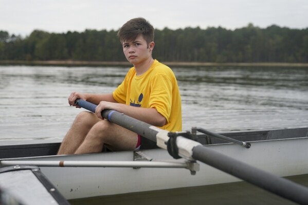 Callum Bradford rows during a club team practice at Jordan Lake, Friday, Oct. 6, 2023, in Apex, N.C. Bradford, a transgender teen from Chapel Hill needed mental health care after overdosing on prescription drugs. He was about to be transferred to another hospital due to a significant bed shortage. A North Carolina hospital network is referring transgender psychiatric patients to treatment facilities that do not align with their gender identities. Though UNC Hospitals policy discourages the practice, administrators say a massive bed shortage is forcing them to make tough decisions. (AP Photo/Erik Verduzco)