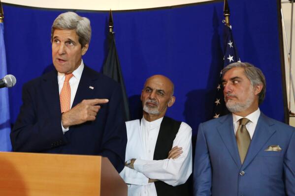 FILE - In this Friday, Aug. 8, 2014 file photo, U.S. Secretary of State John Kerry, from left, speaks as Afghan presidential candidates Ashraf Ghani Ahmadzai and Abdullah Abdullah listen during a joint press conference in Kabul. Afghanistan's two presidential candidates were set to a sign a power-sharing deal on national TV on Sunday, three months after a disputed runoff that threatened to plunge the country into turmoil and complicate the withdrawal of U.S. and foreign troops. (AP Photo/Rahmat Gul, File)