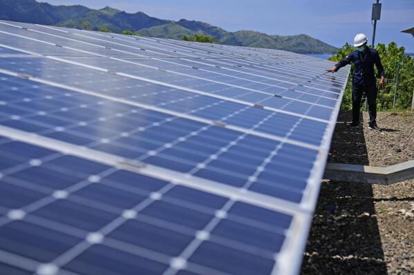 A worker inspects solar panels at a solar power plant on Karampuang Island, in West Sulawesi, Indonesia, Thursday, Dec. 22, 2022. While Indonesia has vast renewable and green energy potential from solar, wind, geothermal and other sources, experts warn that the vast archipelago nation faces unique financial, policy, infrastructure and other challenges that will require innovation.(AP Photo/Dita Alangkara)
