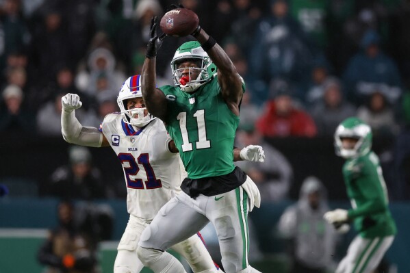 FILE - Philadelphia Eagles wide receiver A.J. Brown (11) makes a catch as Buffalo Bills safety Jordan Poyer (21) defends during an NFL football game Nov. 26, 2023, in Philadelphia. The Eagles and Brown have agreed to a three-year contract extension. (AP Photo/Rich Schultz, File)