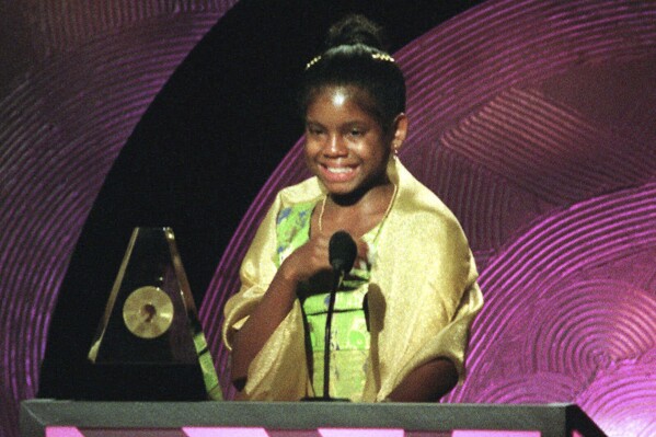 FILE - Hydeia L. Broadbent, 14, speaks after receiving an Essence Award during the taping of the 1999 Essence Awards in New York on Friday, April 30, 1999. Broadbent, who was born with HIV and has been living with full-blown AIDS since age 5, has become a powerful spokesperson and AIDS activist. Broadbent, a prominent HIV/AIDS activist known for her inspirational talks in the 1990s as a young child to reduce the stigma surrounding the virus she was born with, has died. She was 39. (AP Photo/Stuart Ramson, File)