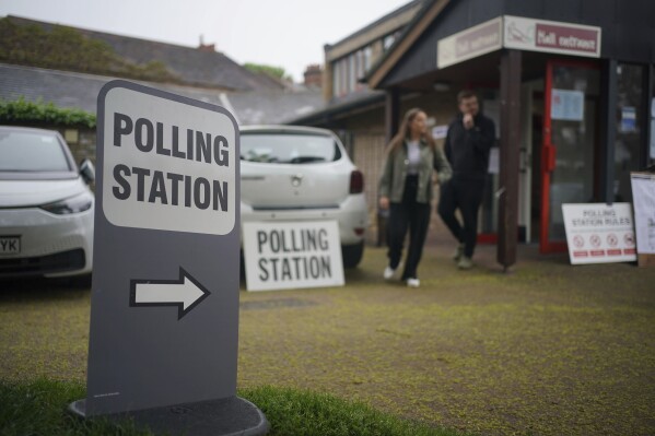 Voters leave a polling station at St Alban's Church, south London, after casting their votes in the local and London Mayoral election Thursday, May 2, 2024. (Yui Mok/PA via AP)