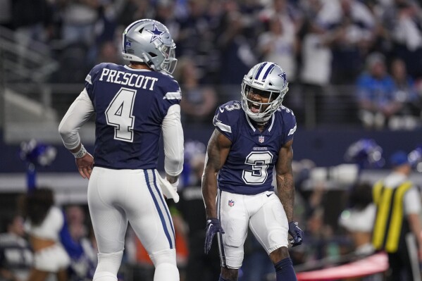 Dallas Cowboys quarterback Dak Prescott (4) and wide receiver Brandin Cooks (3) react after they combined for a touchdown pass and catch against the Detroit Lions during the second half of an NFL football game, Saturday, Dec. 30, 2023, in Arlington, Texas. (AP Photo/Sam Hodde)