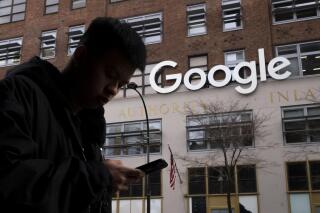 FILE - A man using a cell phone walks past Google offices on Dec. 17, 2018, in New York. Attorneys debated the proper jurisdiction for settling a legal challenge to the first-in-the-nation tax on digital advertising during arguments before Maryland's highest court on Friday, May 5, 2023. Attorneys for Big Tech companies like Facebook, Google and Amazon have contended the law unfairly targets them. (AP Photo/Mark Lennihan, File)