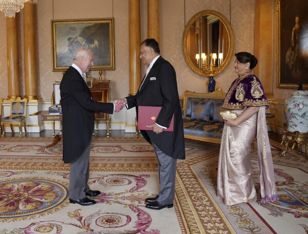 Rohitha Bogollagama, High Commissioner for the Democratic Socialist Republic of Sri Lanka, presents his credentials to Britain's King Charles III, accompanied by his wife Deepthi Bogollagama, during a private audience at Buckingham Palace, London, Thursday May 30, 2024. (Yui Mok/Pool Photo via AP)