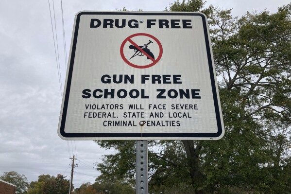 A sign warns of a gun-free school zone, Wednesday, Oct. 25, 2023, in Winder, Ga. Georgia Lt. Gov. Burt Jones says he wants to pay a $10,000 yearly stipend to teachers who pass firearms training, allowing them to carry guns in school. (AP Photo/Jeff Amy)