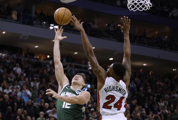 Milwaukee Bucks guard Grayson Allen (12) shoots against Miami Heat forward Haywood Highsmith (24) during overtime in Game 5 of an first-round NBA basketball playoff series Wednesday, April 26, 2023, in Milwaukee. The Heat won 128-126, eliminating the Bucks from the playoffs.(AP Photo/Jeffrey Phelps)