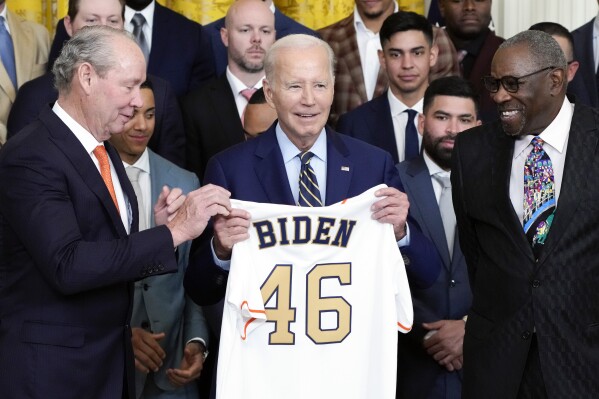 Houston Astros owner Jim Crane and Houston Astros manager Dusty Baker Jr., right, present a jersey to President Joe Biden during an event celebrating the 2022 World Series champion Houston Astros baseball team, in the East Room of the White House, Monday, Aug. 7, 2023, in Washington. (AP Photo/Jacquelyn Martin)