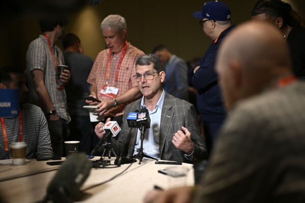 Los Angeles Chargers head coach Jim Harbaugh talks with reporters during an AFC coaches availability at the NFL owners meetings, Monday, March 25, 2024, in Orlando, Fla. (AP Photo/Phelan M. Ebenhack)