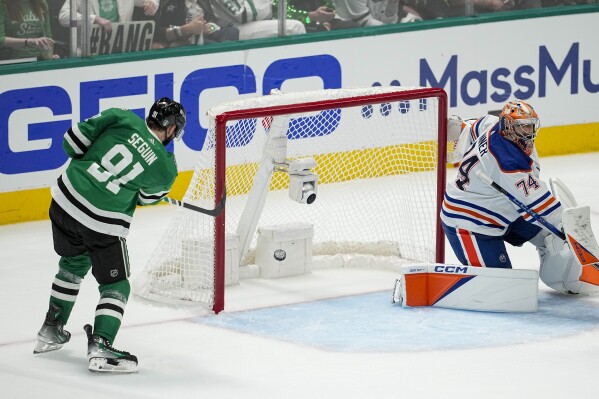 Dallas Stars center Tyler Seguin (91) scores a goal on Edmonton Oilers goaltender Stuart Skinner (74) during the third period in Game 1 of the NHL hockey Western Conference Stanley Cup playoff finals, Thursday, May 23, 2024, in Dallas. (AP Photo/Tony Gutierrez)