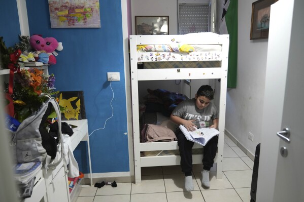 Riad Zaheda reads a book in his room, in Rome, Sunday, March 2, 2025. (AP Photo/Alessandra Tarantino)