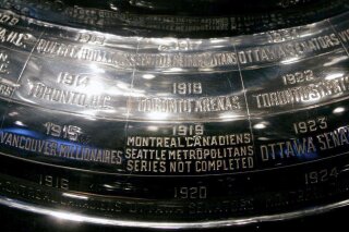 FILE - In this Feb. 4, 2005, file photo, the inscription on the Stanley Cup showing the 1919 series, the only series in the history of the cup not completed, is shown at the Hockey Hall of Fame in Toronto. Anyone who scoffs at drastic measures to deal with the coronavirus outbreak, who wonders if it was really necessary to shut down sports around the world, needs to learn the tragic story of the 1919 Stanley Cup Finals. It's right there on the silver chalice, engraved alongside all the championship teams. "Series not completed." (Adrian Wyld/The Canadian Press via AP