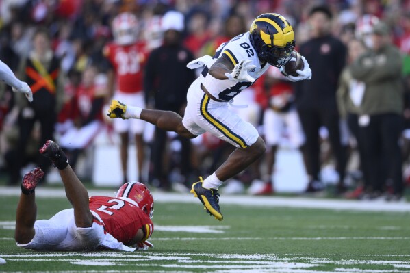 Michigan wide receiver Semaj Morgan (82) leaps past Maryland defensive back Beau Brade (2) during the second half of an NCAA college football game, Saturday, Nov. 18, 2023, in College Park, Md. Michigan won 31-24. (AP Photo/Nick Wass)