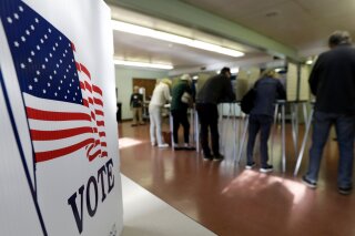 FILE - In this Nov. 6, 2018, file photo, voters cast their ballots, in Gates Mills, Ohio. An Associated Press review has found that thousands of Ohio voters were held up or stymied in their efforts to get absentee ballots by mail in 2018's general election because of a missing or mismatched signature on their ballot application. (AP Photo/Tony Dejak, File)
