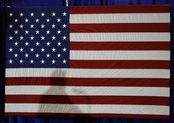 
              FILE - In this Aug. 31, 2018, file photo, President Donald Trump's shadow is shown on an American flag as he speaks before signing an executive order at the CPCC Harris Conference Center in Charlotte, N.C. A majority of Americans disapprove of the way President Donald Trump is handling U.S. foreign policy and about half think the country’s global standing will deteriorate during the next year, according to new poll about the state of the nation’s affairs with the world. (AP Photo/Chuck Burton, File)
            
