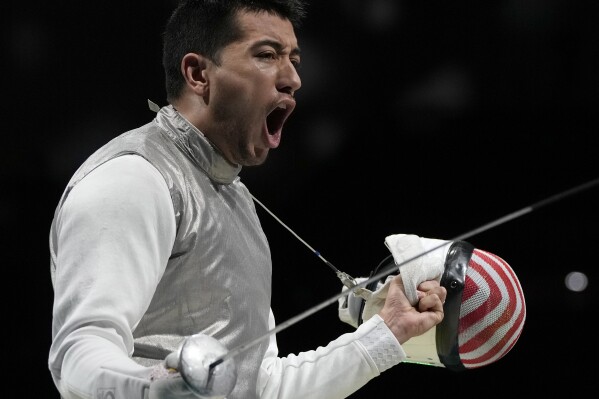 FILE - Gerek Meinhardt, of the Unites States, celebrates after winning a point as he competes against Vladislav Mylnikov, of the Russian Olympic Committee, in the men's foil team semifinal competition at the 2020 Summer Olympics, Aug. 1, 2021, in Chiba, Japan. Meinhardt is a two-time bronze medalist in men's team foil and Lee Kiefer is the reigning women's foil gold medalist; together they are fencing's power couple. (AP Photo/Hassan Ammar, File)
