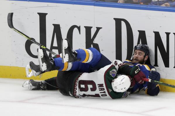 St. Louis Blues' Ryan O'Reilly (90) and Arizona Coyotes' Dysin Mayo (61) fall to the ice during the third period of an NHL hockey game Tuesday, Nov. 16, 2021 in St. Louis. The Coyotes won 3-2. (AP Photo/Tom Gannam)